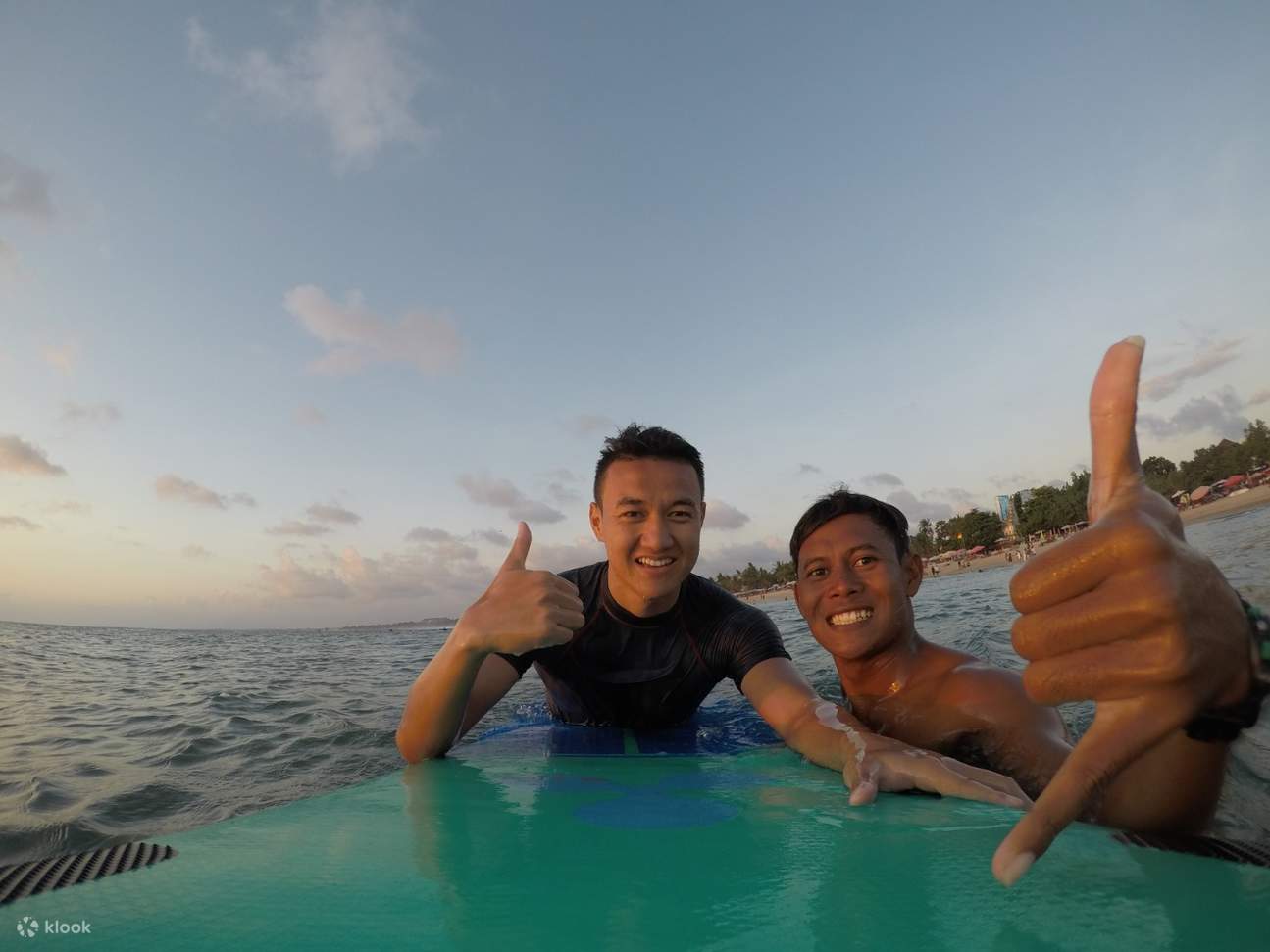 dua lelaki bergambar sambil memegang papan luncur